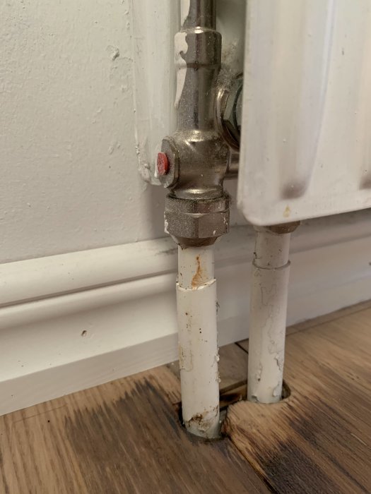 Radiator med möjlig vätskeläckage och rostskador vid golvkontakt.