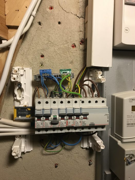 Elcentral med säkerhetsbrytare och distribuerade kablar redo för en trefasgrupps installation.