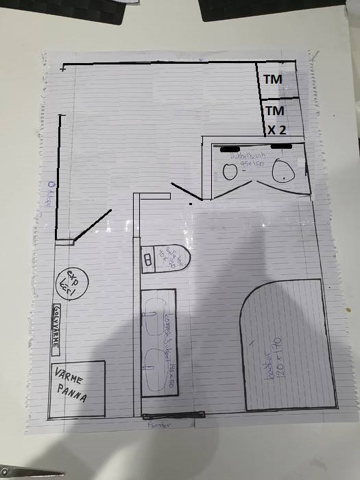 Handritad planritning av badrum med dubbel dusch, tvättmaskin och annan inredning.