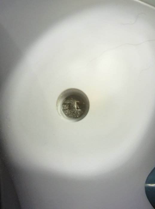 Närbild på en säkerhetsskruv inuti en apparat, med ovanlig skruvhuvud som kräver specialverktyg.