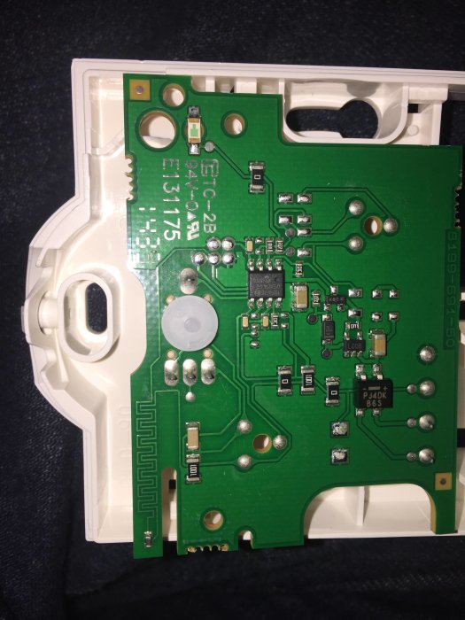Öppen elektronisk termostatvisning med synlig kretskort och komponenter, inomhus användning.