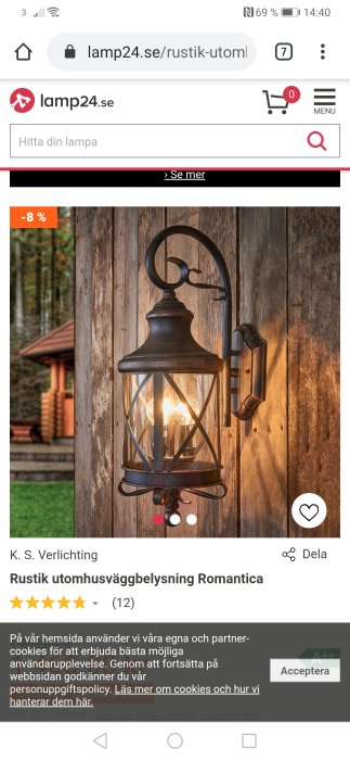 Rustik vägglampa med svart metallram och klart glas, upplyst och monterad på trävägg.