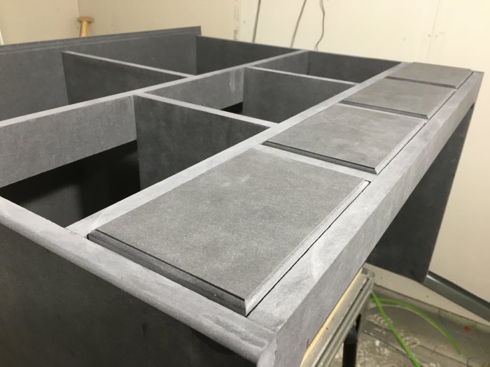 Handgjorda fejk-lådor i grått, uppvisar detaljer på förfalskad möbelstruktur.