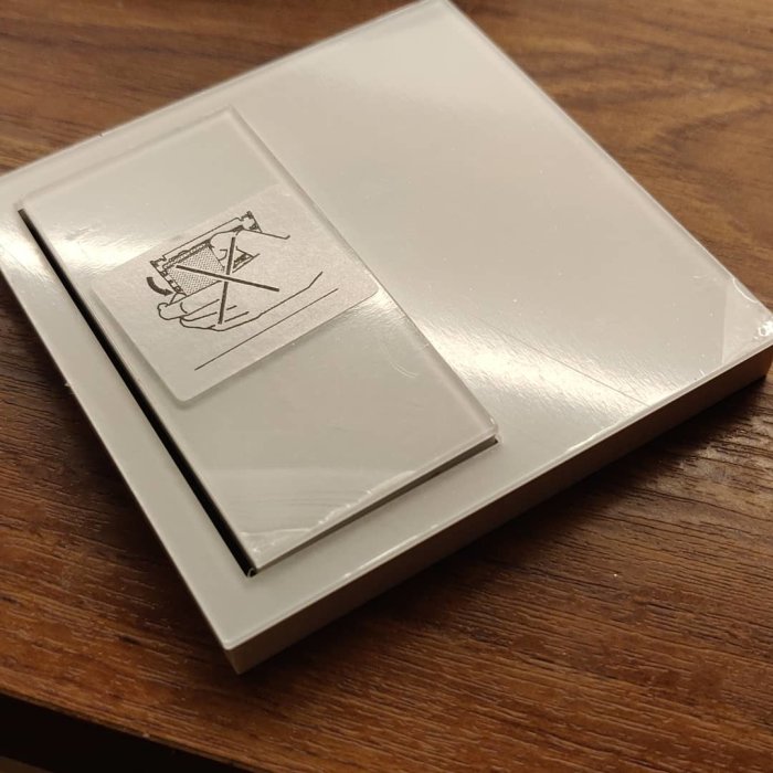 Strömbrytare och slimmade vägguttag på träyta, vita och modern design.