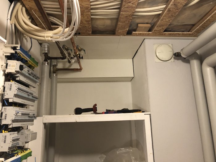 Installation i utrymme med synligt tak, rördragning och elcentral.
