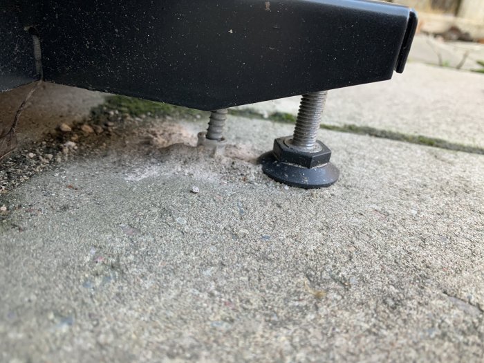 Närbild på vibrationsdämpare under utrustning, monterade på en betongplatta.