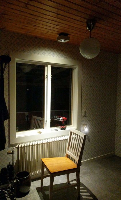 Inredningsrum med takspots Philips hue, fönster och trästol, obefintlig taklist, kvällsbelysning.