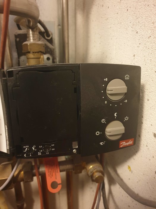 Danfoss ECL 100 styrpanel för värmesystem med justerade inställningar, monterad på väggen.