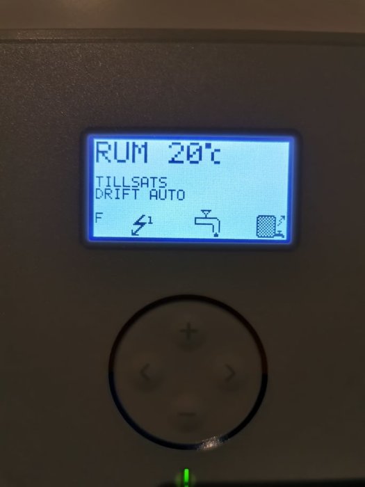 Display av värmepumpsstyrning som visar rumstemperatur 29°C och tillsatsdrift med automatikfunktion.