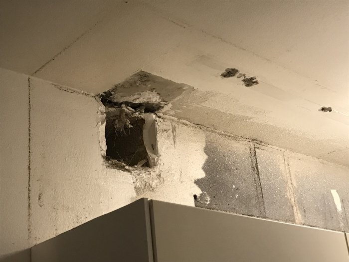 Öppet ventilationshål i tak med synliga smutsränder ovanför ett skåp i ett kök.
