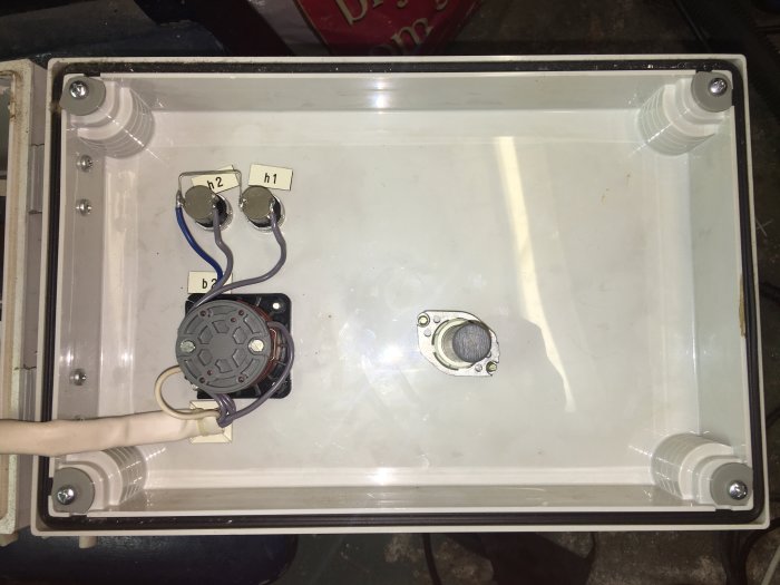 Elektronisk apparat med kablar och anslutningar, tidigare en del av en grundvattenvärmepump, nu överbliven i källaren.