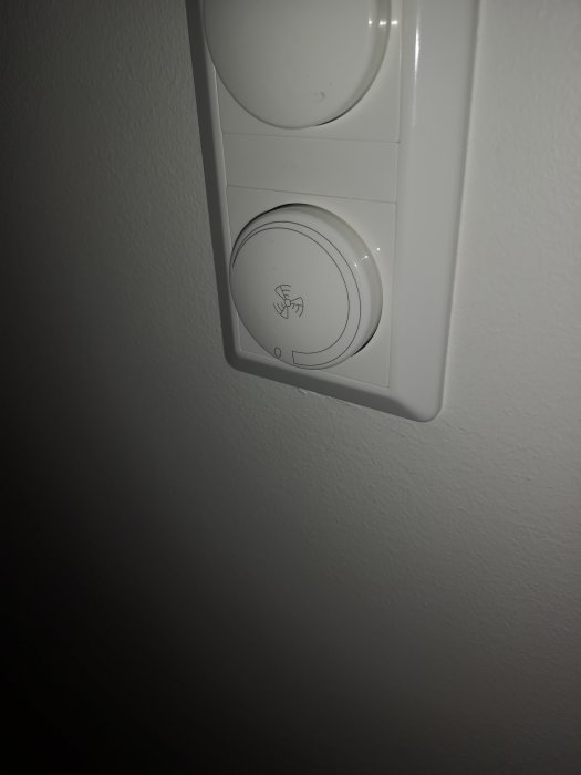 Termostat för värmesystem monterat på vit vägg.