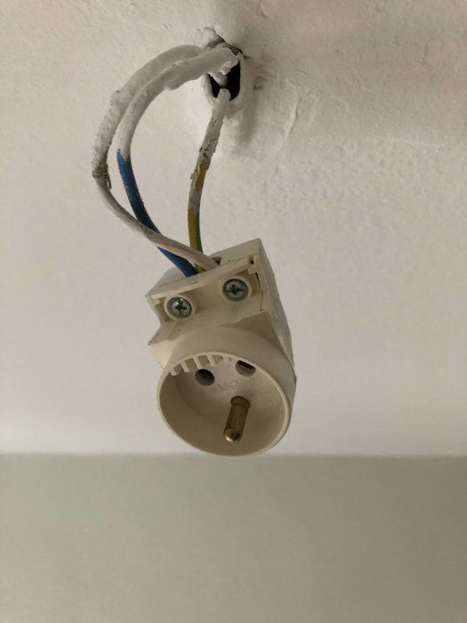 Ojordat lamputtag i tak med synliga kablar och utan armaturdoslock.