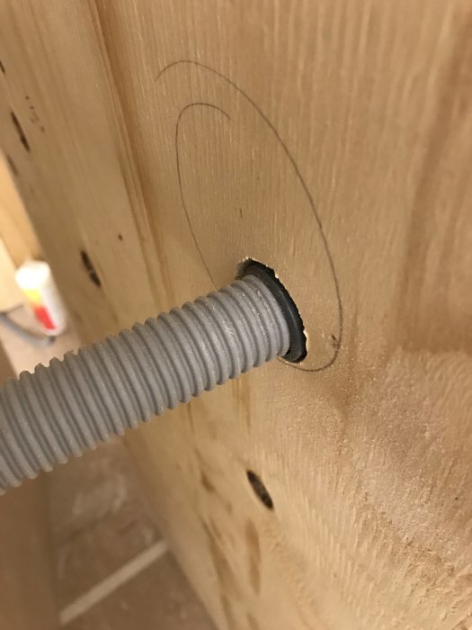 LK rör i rör Uponor fixtur monterad på plywoodvägg, med utmärkt cirkel för kommande gipskivan.