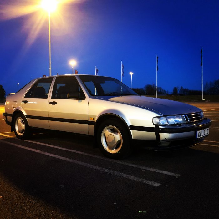 Silverfärgad Saab 9000 CSE från 1996 parkerad under gatlykta i skymningen.