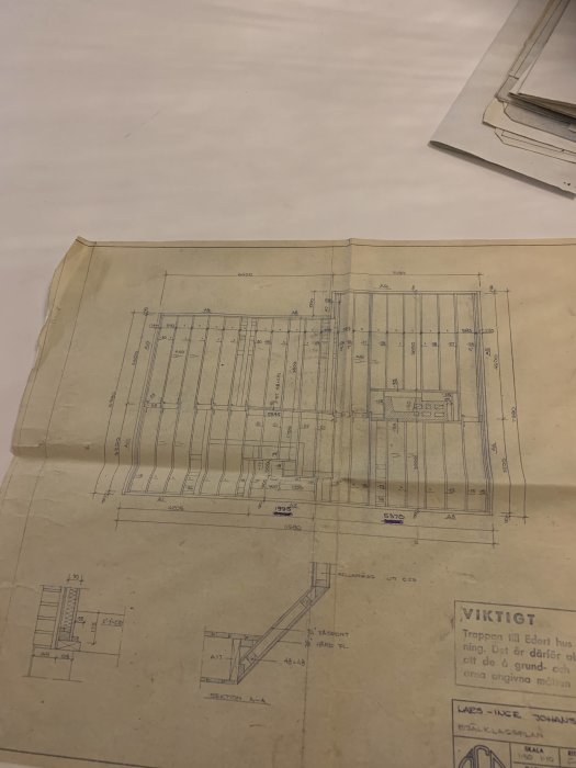 Gammalt ritningspapper med tekniska ritningar av en husplan, eventuellt en våning inklusive detaljer kring en garderob.
