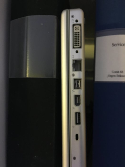 Närbild av en enhets sidopanel som visar olika kontakter, inklusive USB- och nätverksportar.