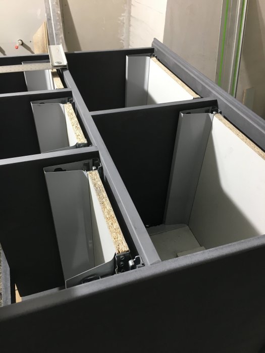 Öppna svarta lådor för förvaring monterade i en stomme under byggnation.