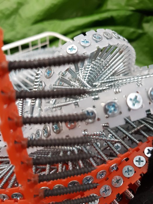 Diverse bandskruv i olika storlekar och för olika material, sorterade i en trådback.