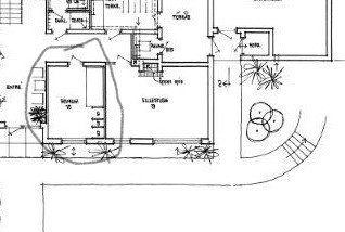 Svartvit ritning av husplan med inringat område för golvvärme och isoleringsprojekt.