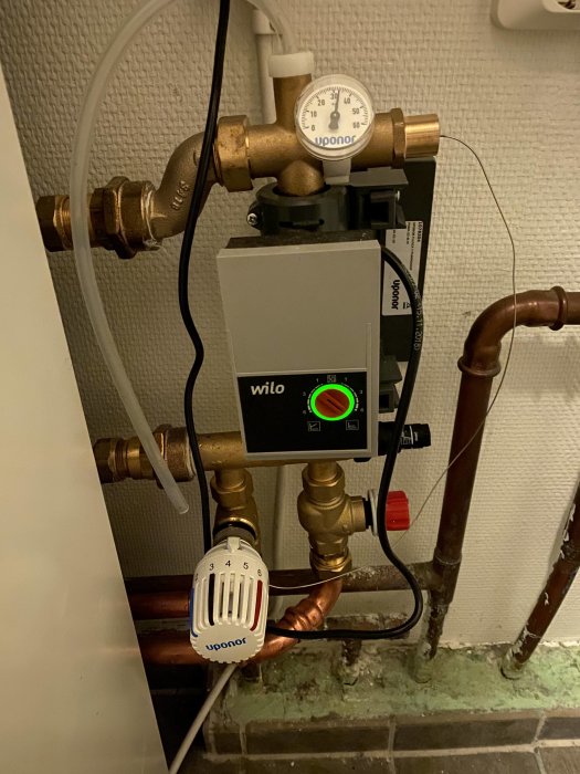 Uponor värmesystem med termometer, Wilo cirkulationspump och termostatventil för hus i Uppsala.