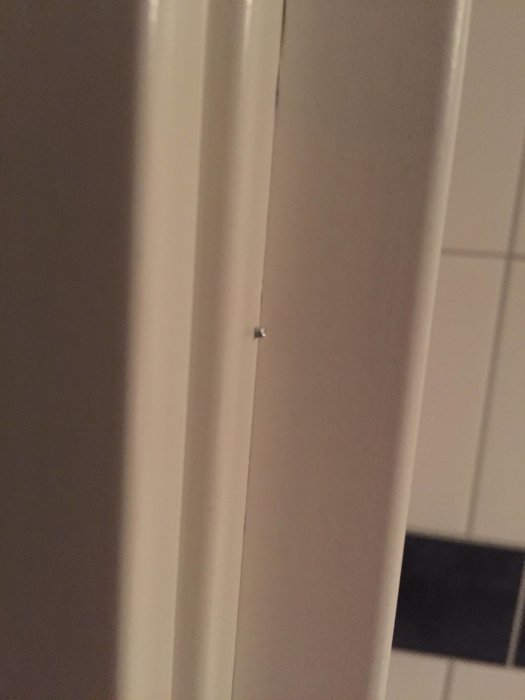 Kylpyhuoneen oven karmissa pieni ulkoneva naula.
