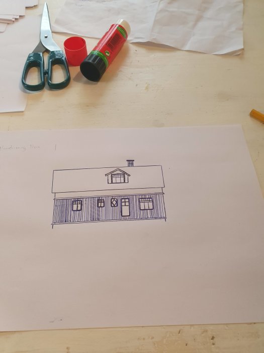 Ritning på en tillbyggd övervåning på ett hus, med verktyg på ett bord.