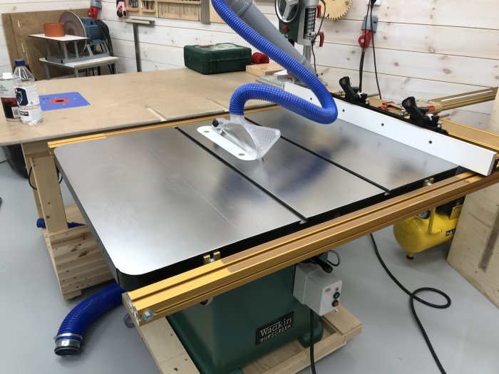 Nyslipat bordsågsbord i verkstad utan rostfläckar och synligt lim, ser välunderhållet ut.