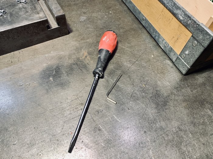 Skruvmejsel och insexnyckel på en arbetsbänk som en del av ett pågående byggprojekt.