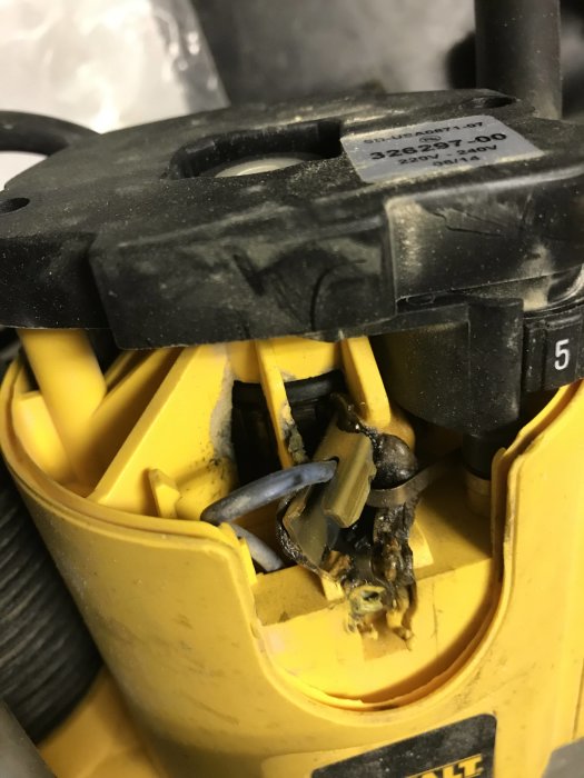 Skadad DeWalt DW621 elverktyg där plasten smält vid kolborsten.