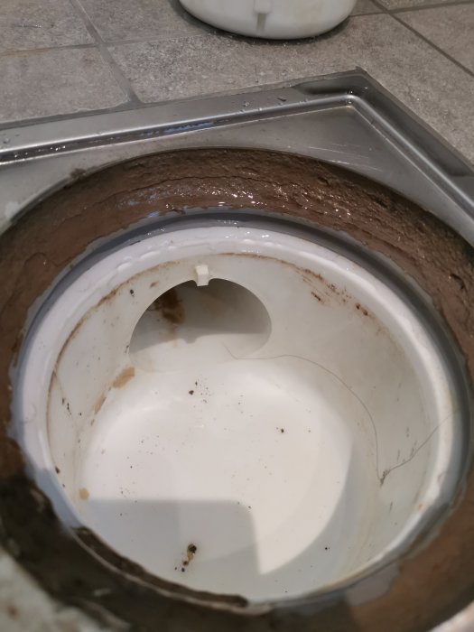 Närbild av ett öppet avloppsrör i badrum efter renovering för kontroll av våtrumscertifikat.