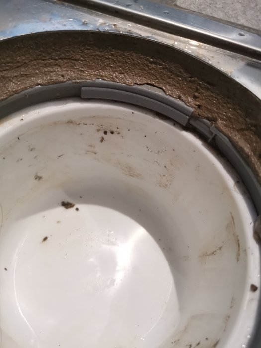Rengjord men fläckig toalettstol med synliga rester vid kanten i badrum.
