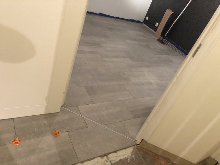 Nyinstallerade klinkergolv med pågående arbete, verktyg synliga, rum i bakgrunden.