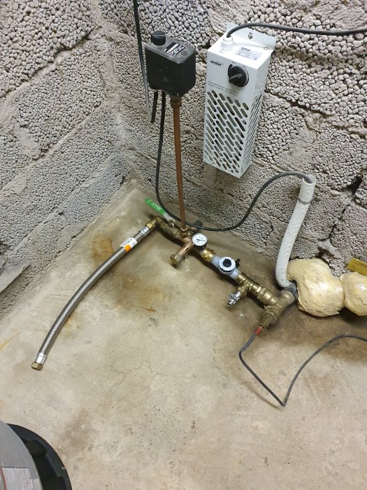 Installation av vattenfilter och hydrofor i källare med synliga rör och kopplingar.