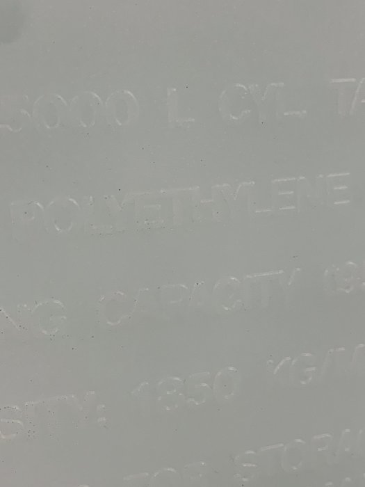 Prägling på en polyethylenbehållare med texten "Polyethylene" och andra specifikationer.