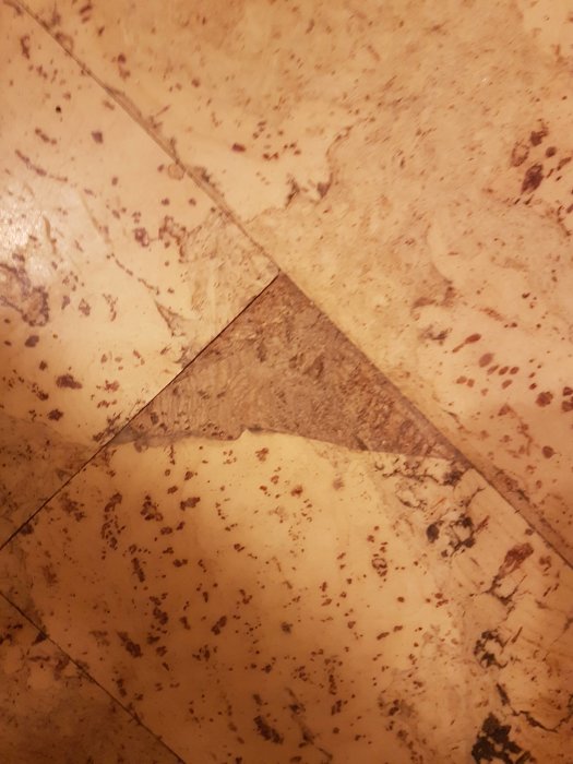 Slitet golv med misstänkt asbest, visar sprickor och slitage på ytan.