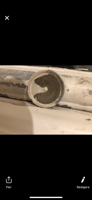 Gammal rund ventil märkt "Vento Ventilator Stockholm" insatt i ett fönsterkarm, behöver demonteras.