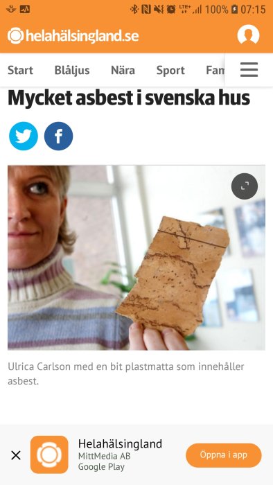 Kvinna visar en bit av en gammal slitna plastmatta som misstänks innehålla asbest.