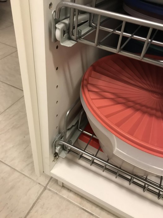 Trådkorg monterad i vit skåpsstomme, skiljer 5 cm i djup till skåpets sida, kärl delvis synligt.