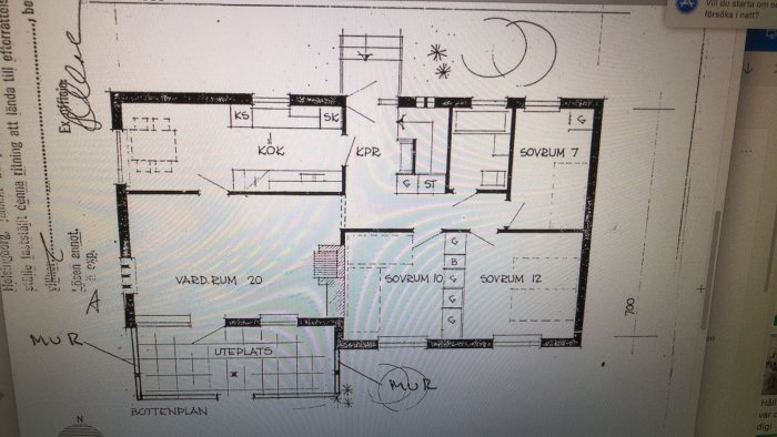 Ritning av bottenvåningen till ett hus med markeringar för kök, vardagsrum och sovrum, fotograferad på en datorskärm.