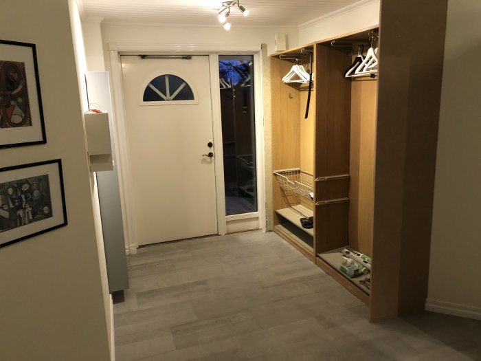 Renoverat rum med nylagt klinkergolv, pågående inbyggnad av garderob och dörr i bakgrunden.