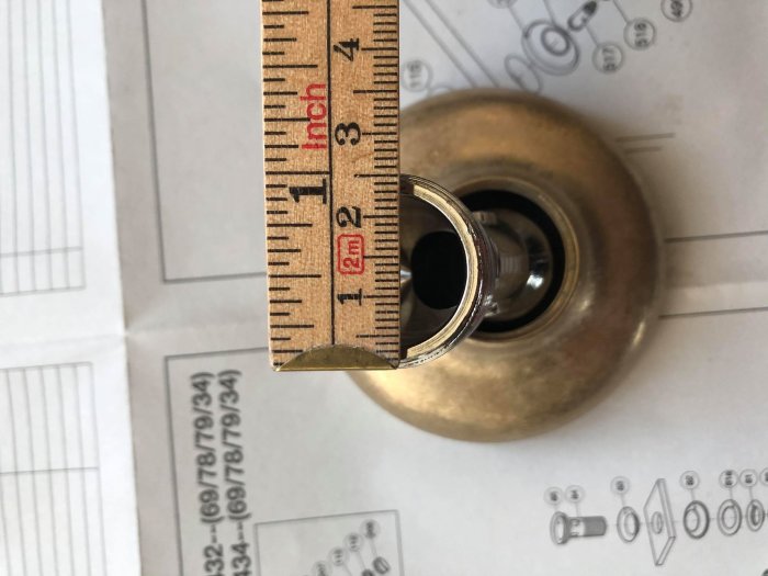 Måttband visar 1½ tum vid mätning av en rördel ovanpå teknisk ritning.