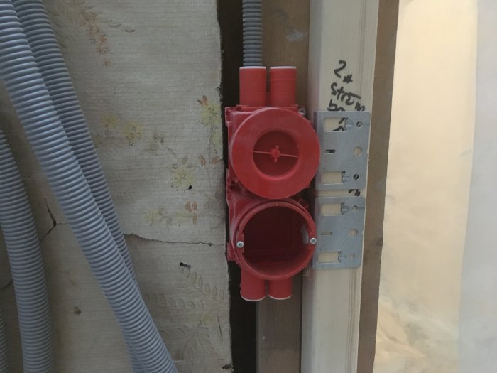 Röda ELKO-elektrikerdosor monterade i vägg med synliga elrör och anteckning.