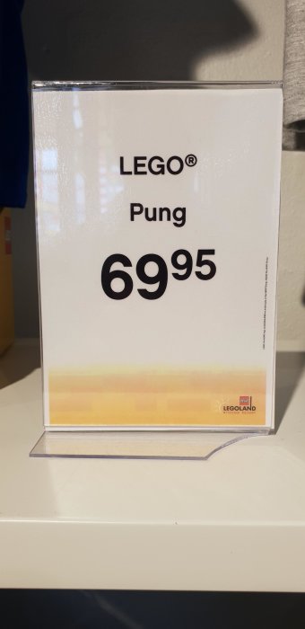 Prisetikett med texten "LEGO® Pung 6995" framför en suddig bakgrund.