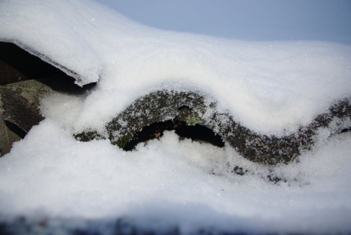 Takpannor täckta med snö, närbild på en snöig vintertid.