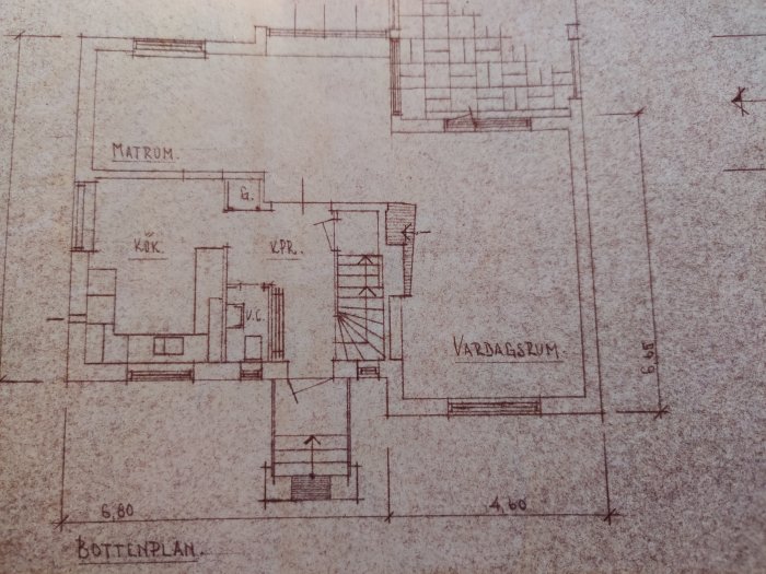 Pohjapiirros, joka näyttää keittiön, ruokailuhuoneen ja olohuoneen sijoittelun talossa. Huoneiden välisiä seinälinjoja on merkitty.