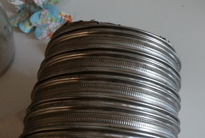 Bild på ett flexibelt metallrör som är dåligt tätat vid anslutningen, används tillsammans med spisfläkt.