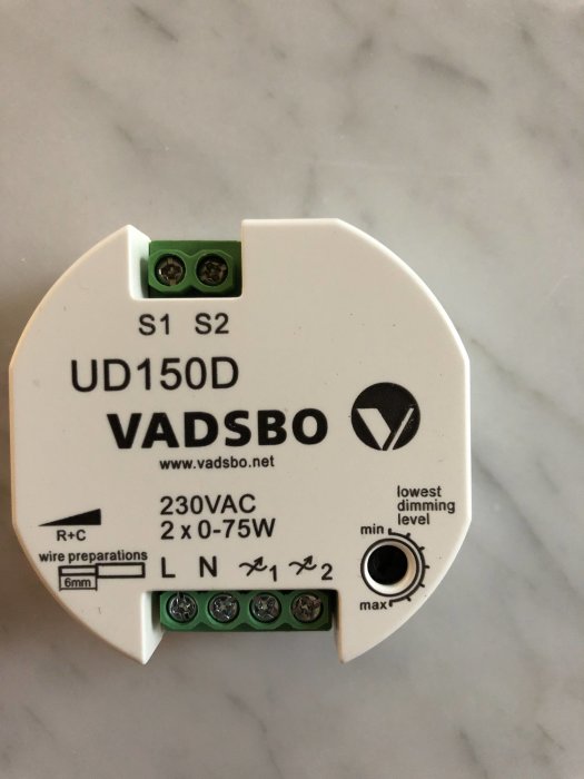 Vit dimmermodul från VADSB0 med märkning UD150D och anslutningsterminaler på en marmorbänk.