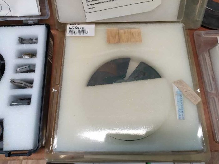Ett paket med en rundad fönsterglasdel, inpackad i skyddande skummaterial på en arbetsbänk.
