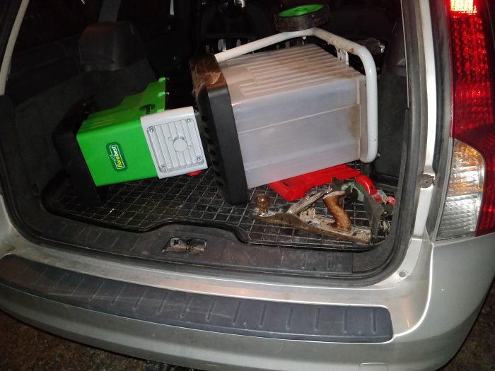 En kompostkvarn och gamla verktyg, inklusive hyvlar, i bagageutrymmet på en bil, redo för bortforsling.